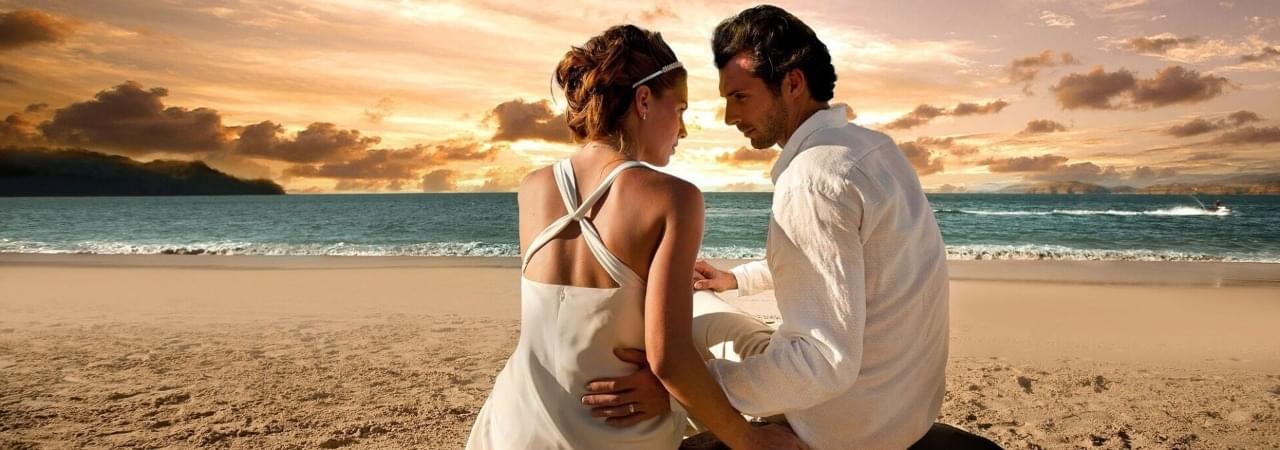 pareja en la playa con atardecer de fondo