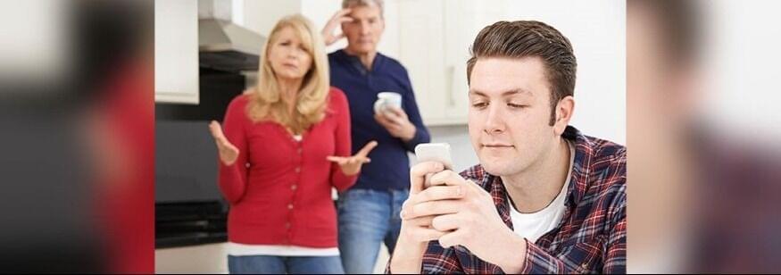 joven mira el teléfono ignorando a sus padres